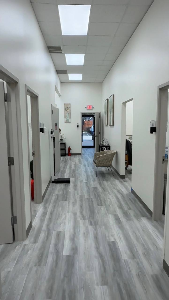 Finished commercial hallway — gray LVP, white walls, office doors